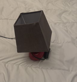 Lampe galet rouge et noir avec phare décoratif